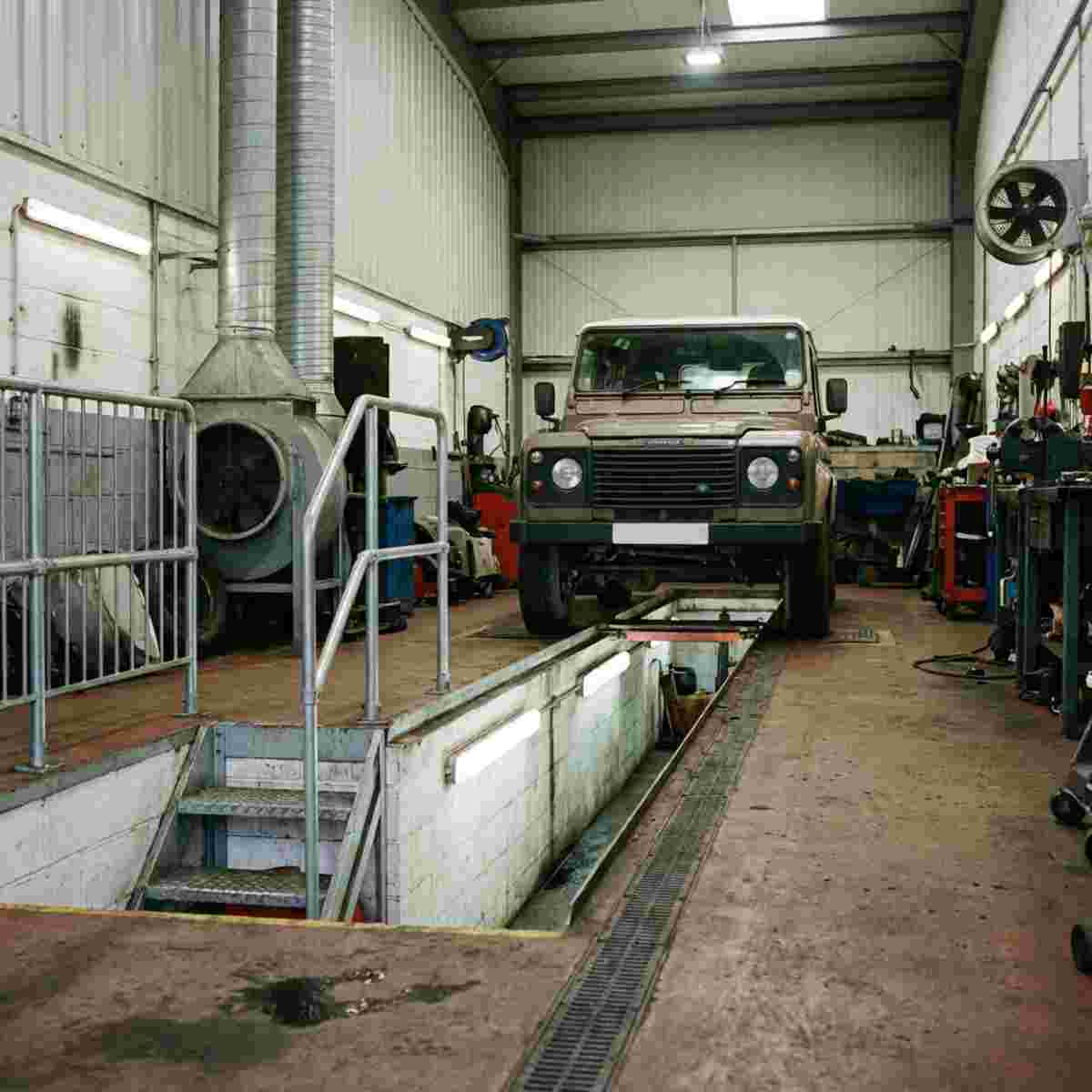 Fotorealistische quadratische Autowerkstatt mit Prüfgrube, Fahrzeug darüber, Beleuchtung